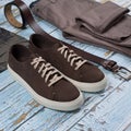 Men casual outfit. Men`s shoes, clothing and accessories on wooden background - jeans, shirt, sneakers, belt. Top view. Flat lay Royalty Free Stock Photo