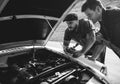 Men Checking Broke Down Car on Street Side with Open Hood