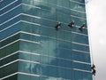 Men cleaning glass building by rope access at height Royalty Free Stock Photo