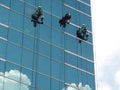 men cleaning glass building by rope access at height Royalty Free Stock Photo