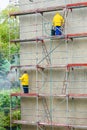 Men cleaning wall. Scaffolding Royalty Free Stock Photo