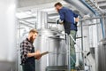 Men with clipboard at brewery kettle or beer plant Royalty Free Stock Photo