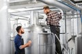 Men with clipboard at brewery kettle or beer plant Royalty Free Stock Photo