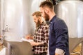 Men with clipboard at craft brewery or beer plant Royalty Free Stock Photo