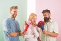 Men competitors with bouquets flowers try conquer girl. Girl likes to be in middle attention. Love triangle. Woman Royalty Free Stock Photo