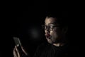 men in the dark facial expression lust while browsing smartphones