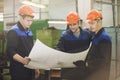 Men with drawings working in an old factory to install the equip Royalty Free Stock Photo