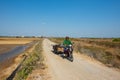 A men drive a homemade motocycle on road at salt field in Ly Nhon, Can gio, vietnam