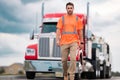 Men driver near lorry truck. Truck driver in safety vest near truck. Hispanic man trucker trucking owner. Transportation