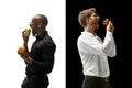 Men eating a hamburger and fruits on a black and white background Royalty Free Stock Photo