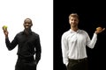 Men eating a hamburger and fruits on a black and white background Royalty Free Stock Photo