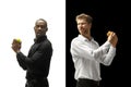 Men eating a hamburger and fruits on a black and white background Royalty Free Stock Photo