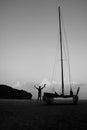 Men enjoying photography with camera near a sailboat on the beach in the evening