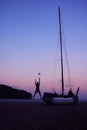 Men enjoying photography with camera near a sailboat on the beach in the evening