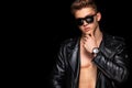 Men fashion. Close-up portrait of a brutal and fit man topless in sunglasses and leather jacket. Athlete bodybuilder on