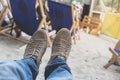 Men feet in sneakers on background of deckchairs on beach Royalty Free Stock Photo
