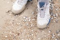 Men feet in sneakers on the beach Royalty Free Stock Photo