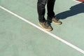 Men feet stand on the rubberized sports ground