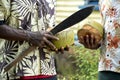 Men in Fiji, machete in hand opening coconut