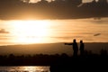 Men fishing at the lake at sunset Royalty Free Stock Photo