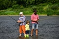 3 men fishing on river in summer time. Grandfather, father and son are fly fishing on river.