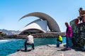 Men fishing in the sea in front of the futuristic auditorium in santa cruz de tenerife