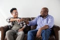 Men fist bumping celebrating on couch Royalty Free Stock Photo