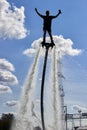 Men on a flyboard with their hands raised to the sky. Extreme sports on the water