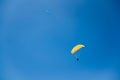 Men Flying over Annecy Lake in Yellow and Blue Paragliders in Blue Sky on a Sunny Day Royalty Free Stock Photo