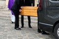 Men of funeral service loading the coffin into the hearse