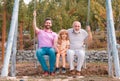 Men generation family playing on swing together Three different generations ages: grandfather father and son swinging Royalty Free Stock Photo