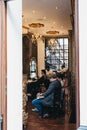 Men getting haircuts inside The Ottoman Crew Turkish Barbershop, London, UK.