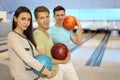 Men and girl smile and hold balls in bowling club Royalty Free Stock Photo