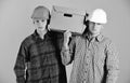 Men with grumpy faces hold cardboard box on pink background. Delivery, warehouse and packaging concept. Siblings with