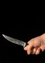 Men hand holds sharp knife isolated against black background Royalty Free Stock Photo