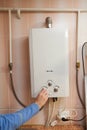 Men hand regulate the power of hot water in Gas water heater.