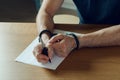Men hands with handcuffs fill the police record, confession. on top of the police investigative detective. Arrest, bail Royalty Free Stock Photo