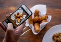 Men hands taking food photo of VENEZUELAN TEQUENOS by mobile phone