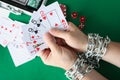 Men hands are tied with chain and hold playing cards closeup Royalty Free Stock Photo