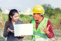 Men in hard hats and uniform with young woman. Team of architects, engineers discussing work