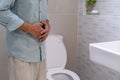 Men have abdominal pain, holding their hands on their abdomen, torturing the face of the toilet in the toilet. The concept of diar