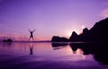 Men are having fun jumping in the morning at sunrise on the beach, reflections on the water surface Royalty Free Stock Photo