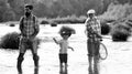 Men hobby. Summer day. Male multi generation family. Family fishermen fishing with spinning reel. Father teaching son Royalty Free Stock Photo