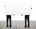 Men holding blank board on wooden floor Royalty Free Stock Photo