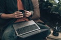 Men holding cup of coffee and using laptop to working, play game, listen music or relaxing on sofa at home. Relax home concept Royalty Free Stock Photo