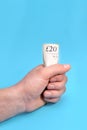 Men holding a 20 pounds in palm on blue background