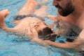 a man holds a disabled child during aquatic therapy in a swimming pool. Royalty Free Stock Photo