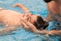 a man holds a disabled child during aquatic therapy in a swimming pool. Royalty Free Stock Photo