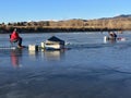 Men ice fishing on blue ice under blue sky 3. Royalty Free Stock Photo