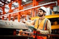 Men industrial engineer wearing a white helmet while standing in a heavy industrial factory behind. The Maintenance looking of